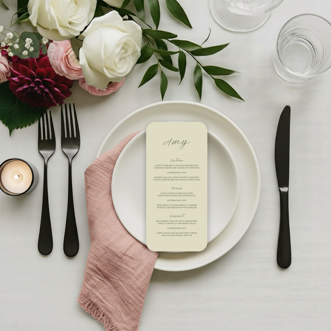 Custom wedding menu on a linen tablecloth with a floral arrangement.