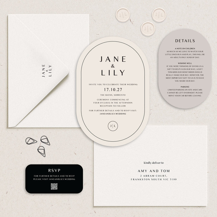 A styled flat-lay of wedding stationery on a light textured background, including an oval invitation card, details card, RSVP card, envelopes, and wax seals.