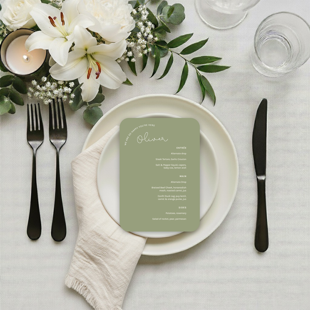 Wedding menu displayed in a gold-framed holder on a table.